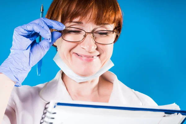 Onun dosyasını arıyor gülümseyen kadın doktor gözlük — Stok fotoğraf