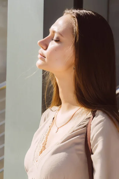 La chica con los ojos cerrados bajo los rayos del sol — Foto de Stock