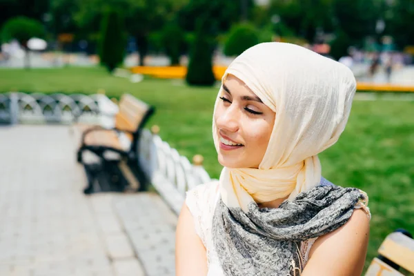 Beautiful Young modern Muslim woman in scarf resting in summer park — Stock Photo, Image