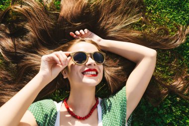 Mutlu sağlıklı gülümseyen kadın gözlük çimen, üstten görünüm yukarıdaki Tarih