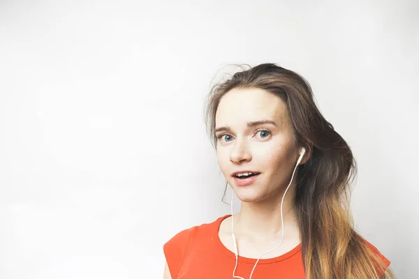 Amazed Woman in earphones, beautiful surprised girl listening to music