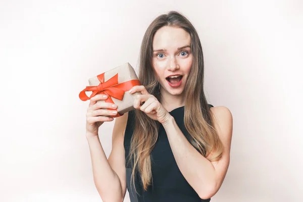 Verrast vrouw tonen geschenk, leuk gelukkig meisje met een cadeau in handen — Stockfoto