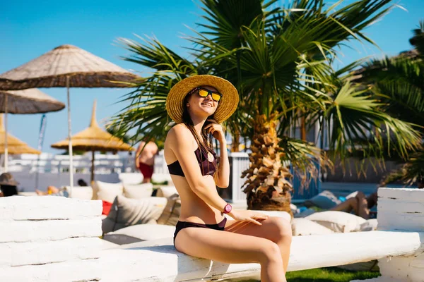 Stile di vita ricco donna rilassante godendo di hotel sulla spiaggia di lusso, palme e ombrelloni intorno, resort costoso, vacanze estive — Foto Stock