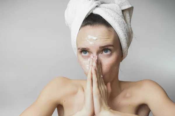 Femme drôle dans une serviette sur la tête heureux nettoie la peau avec de la mousse sur un fond blanc isolé. Concept de nettoyage de la peau — Photo