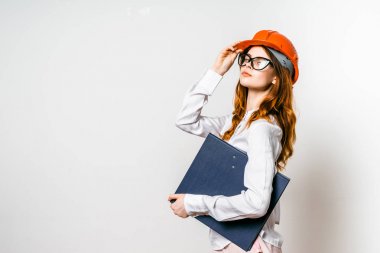 bir kadın bir koruyucu kask içinde belgeleri tutan ve ileri görünüyor