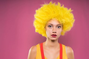 Kız bir sarı peruk ayakta pembe duvar tarafından