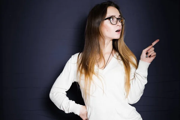 Chica en gafas y una chaqueta blanca muestra su dedo hacia arriba —  Fotos de Stock