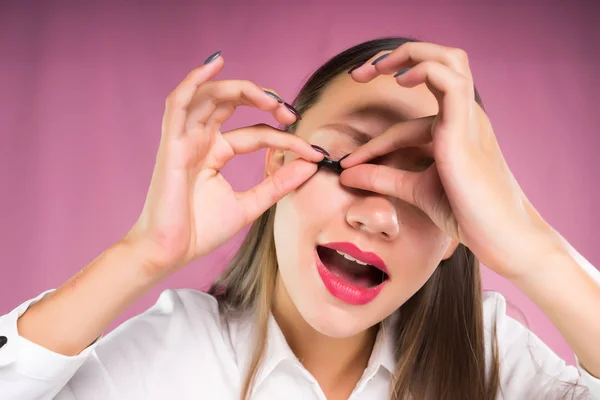 Jovem menina em uma camisa branca remove pestanas falsas — Fotografia de Stock