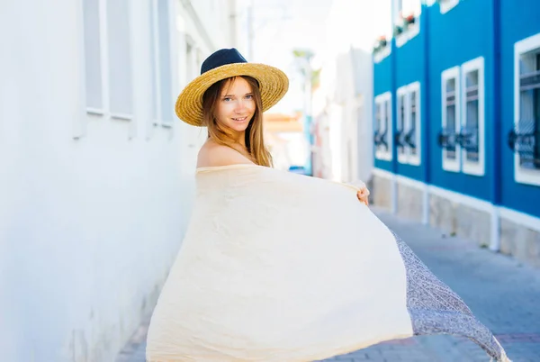 Una chica en un sombrero de paja está caminando por la calle —  Fotos de Stock