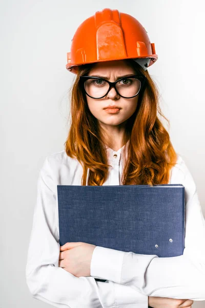 Menina ruiva em um capacete laranja no trabalho — Fotografia de Stock