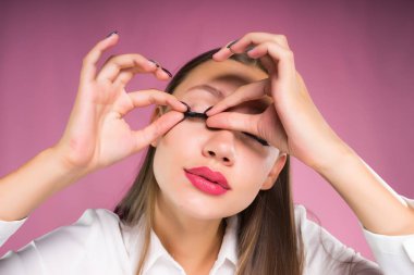 genç kız Beyaz gömlekli sahte kirpik kaldırır