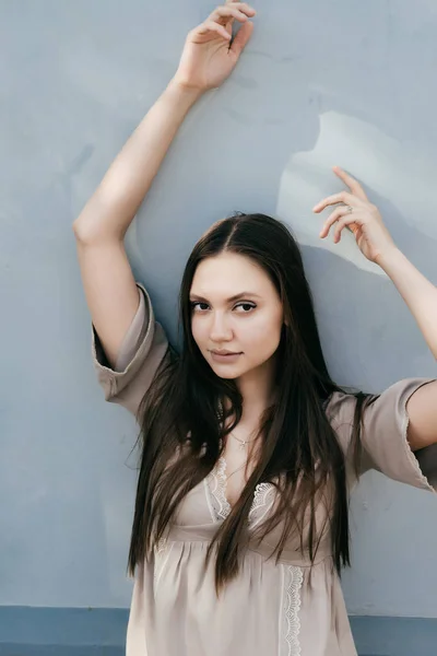 Charmante meisje in lichte blouse poseren tegen muur — Stockfoto