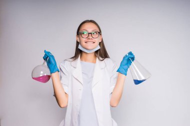 bir kadın bilim adamı gizemli bir şekilde bir şişesi kimyasal onun el ve gülümsüyor tutar