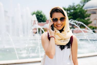 Sokakta telefonda konuşurken genç güzel bir Müslüman kadın portresi