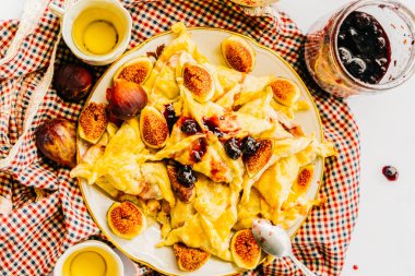 bir plaka ile lezzetli yemekler ve çeşitli içecekler damalı bir masa örtüsü üzerinde olduğunu