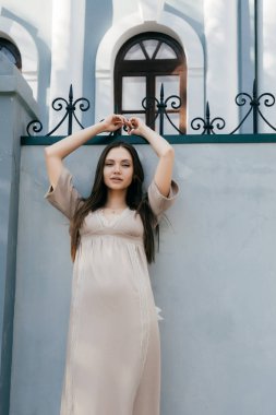 elbiseli kız Duvar tarafından duruyor, o ellerini yukarı doğru kaldırdı