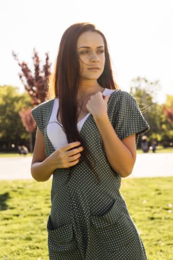 Kız parkta yürüyor ve uzak düşünceli görünüyor