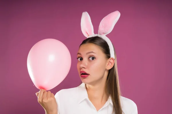可爱的女孩，与 rim 的兔子耳朵形式持有一个粉红色的气球 — 图库照片