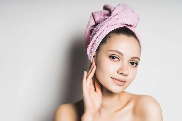 Giovane ragazza con un asciugamano rosa sulla testa e con la pelle pulita sorridente — Foto Stock