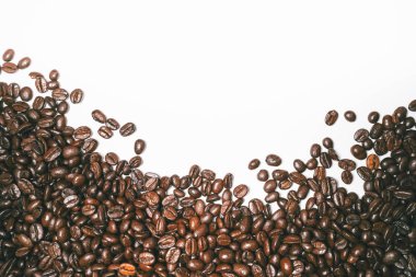 Kahve taneleri güzel beyaz bir yüzey üzerinde dağılmış