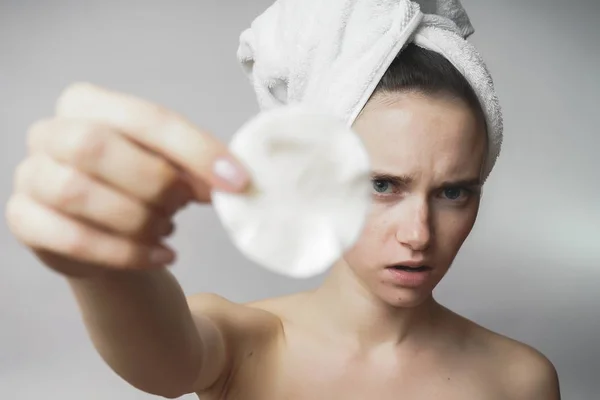 Девушка с полотенцем на голове показывает грязные хлопчатобумажные блокноты — стоковое фото