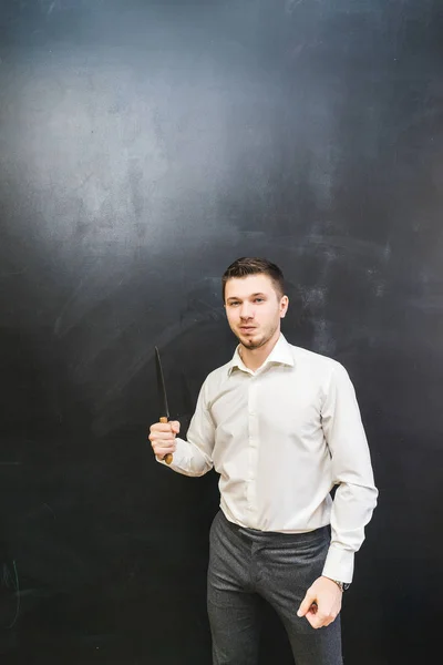 Um jovem de camisa branca está segurando uma faca na mão — Fotografia de Stock