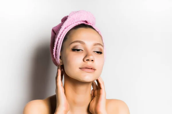 Menina bonita com uma toalha na cabeça cuida de seu rosto — Fotografia de Stock