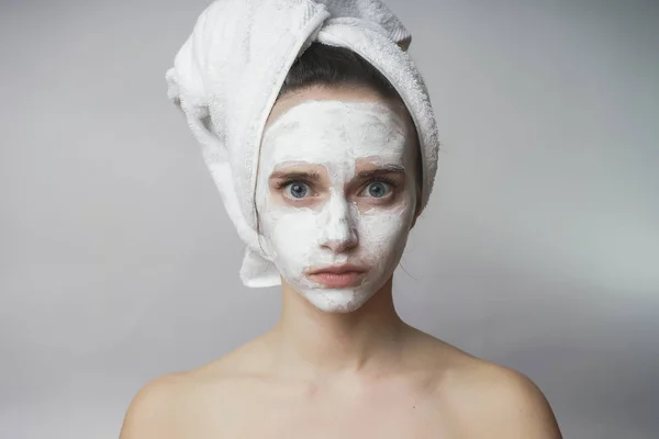 Meglepett asszony lesz fehér maszk az arcon, bozót alkalmazása — Stock Fotó