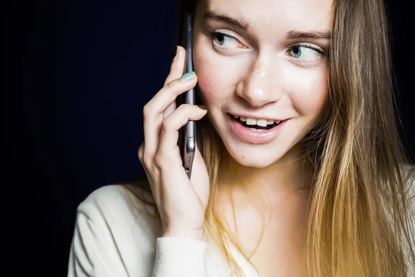 young girl talking to someone on the phone and smiling