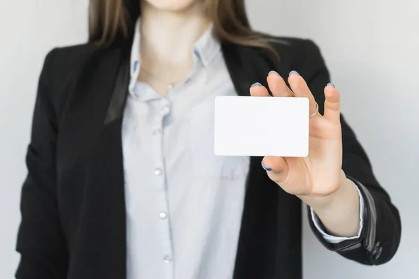 A girl in a black suit is holding something white — Stock Photo, Image