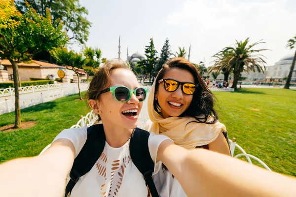 Beyaz diş hekimi gülümsüyor ile iki gülümseyen kız arkadaşım selfie yapmak. Farklı uluslardan, dostluk insanlar