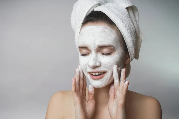 Mujer con cosméticos blancos mack en la cara, exfoliante, hidratante —  Fotos de Stock