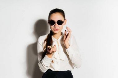 Siyah gözlüklü iş elbiseli kız telefonda konuşan