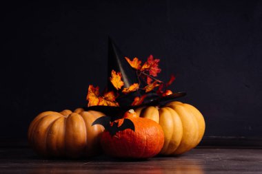 Bir şapka siyah bir arka plan ile bir kaç süslü kabaklar