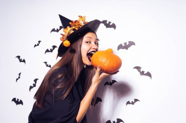 bir kız bir cadının elbiseli küçük bir kabak tutar