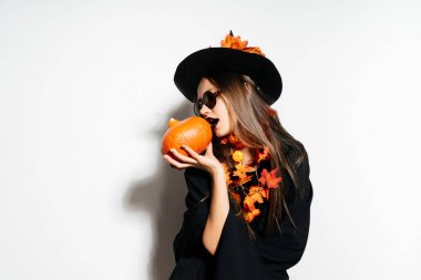 bir kız bir cadının elbiseli küçük bir kabak tutar