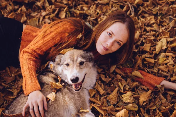 gülümseyen kız köpeğini ile sonbahar yeşillik içinde yatan