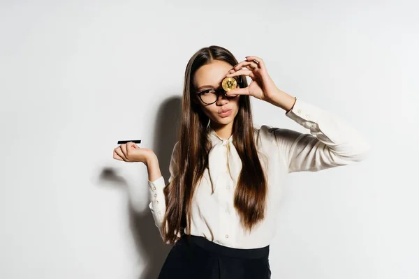 Una chica en gafas sostiene en sus manos unas monedas grandes — Foto de Stock