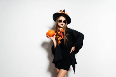 Halloween cadı bir oyulmuş kabak ve koyu gözlük güzel genç sürpriz kadın cadı şapka ve kostüm kabak holding ile. Geniş Cadılar Bayramı partisi sanat tasarım