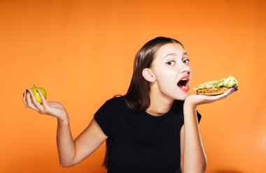 güzel bir kız bir elma ya da ağız sulandıran bir sandviç yemek iyidir seçer. Bir kız bir sandviç ısırmak istiyormuş.