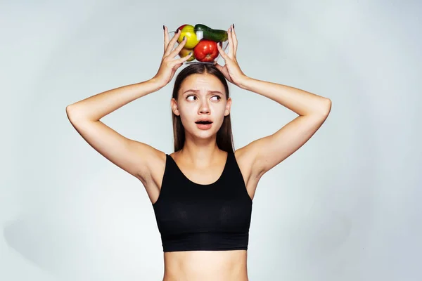Dívka drží misku zeleniny na její hlavu, sport, jóga, správná výživa, zdravé potraviny — Stock fotografie