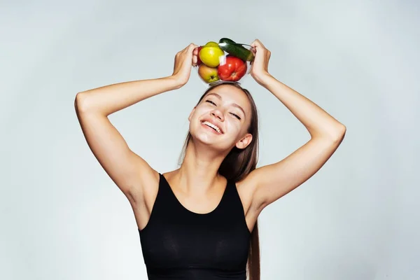 Glada leende flicka som håller en skylt med grönsaker på hennes huvud, hälsosam mat, vacker kropp, hälsosamt liv — Stockfoto