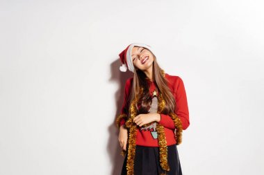 Yeni yıl, yeni yıl ruh hali, Dekorasyon, bir kız bir yılbaşı kazaklı ve Noel Baba şapkası, mutlu Noeller