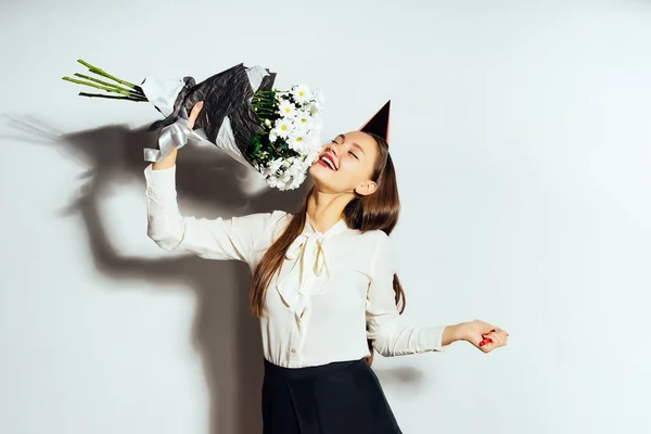 Vacker glänsande flicka med blommor. Födelsedag, feststämning. Flickan i festlig cap — Stockfoto