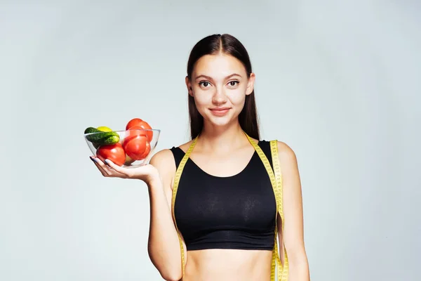 Plattan innehåller god mat vegetariska produkter. Attraktiv kvinna som håller en skylt med röda grönsaker — Stockfoto