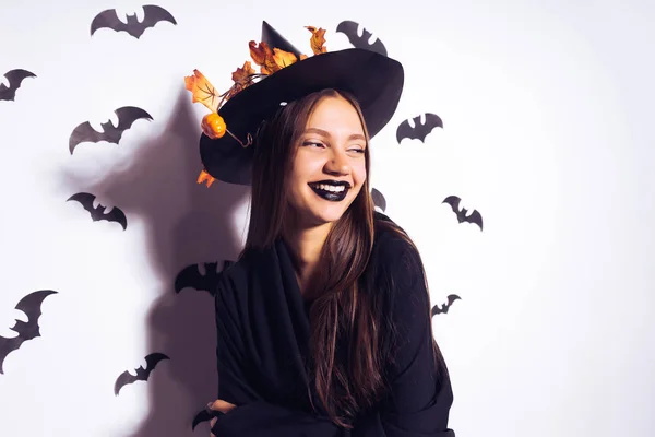 Halloween čarodějnice se usmívá a vypadá pryč. Krásná mladá žena v klobouku čarodějnice a kostýmu. Široký design Halloween party — Stock fotografie