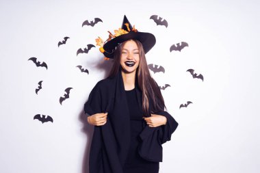Halloween cadı uzun saçlı. Siyah bir takım elbise giymiş bir güzel kız bir partiye gidiyor. Yarasalar arka planı. Geniş Cadılar Bayramı partisi sanat tasarım