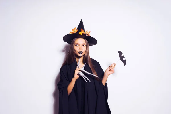 Tajemnicze witch Halloween w Czarną szatę i wielki kapelusz z liści, patrząc od hotelu. Dziewczyna idzie do Halloween party. Stylu Halloween — Zdjęcie stockowe