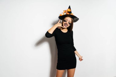 Cadılar Bayramı kadın siyah Cadılar Bayramı elbise ve bir şapka turuncu yaprak ile 