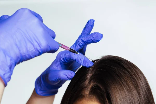 A rapariga foi injectada na cabeça. fortalecimento de cabelo. cabelo longo saudável. um close-up da seringa . — Fotografia de Stock